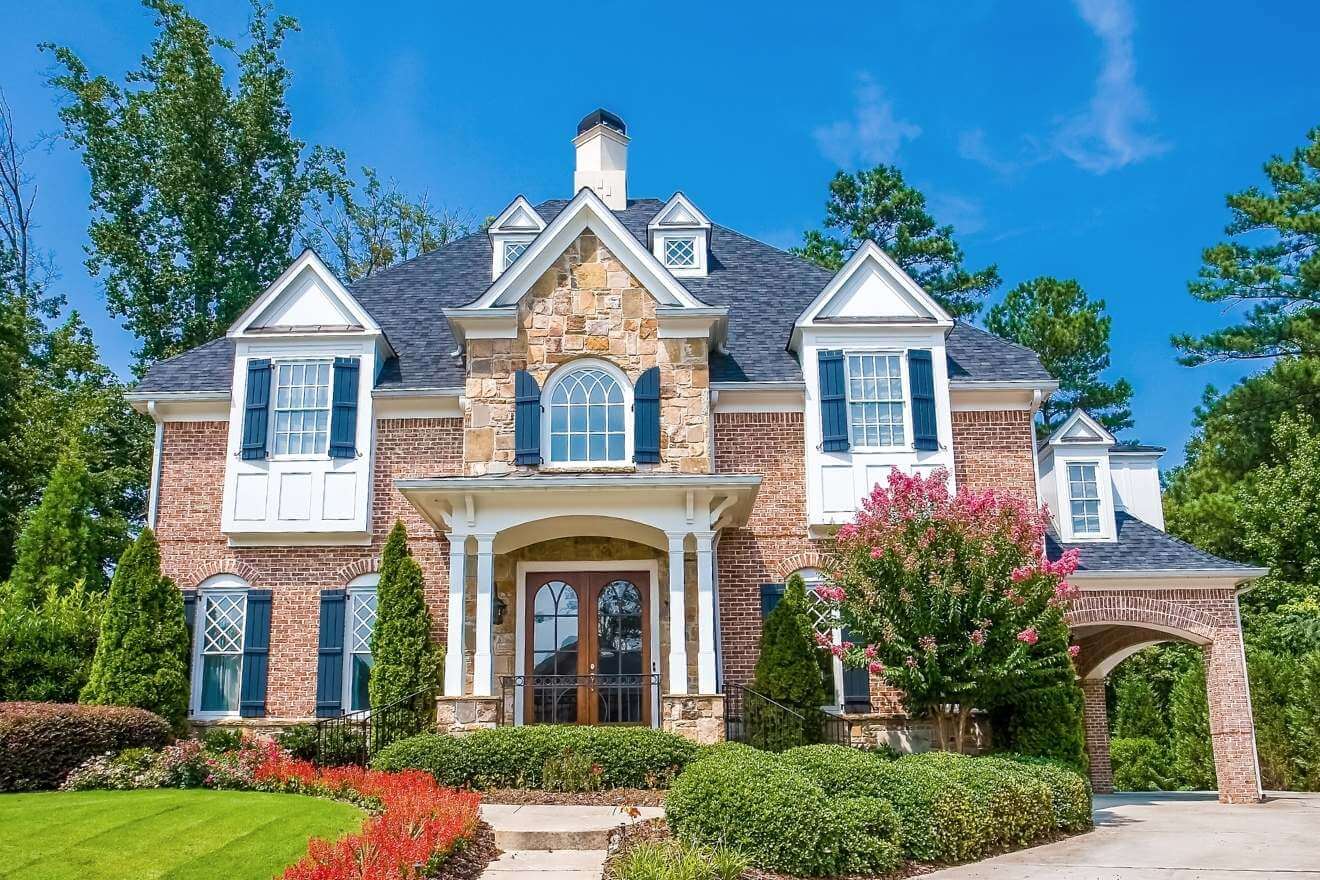 French Provincial Home with brown brick, white ornate features, and romantic touches.